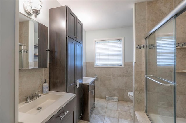 5805 N Belton Ave, Kansas City, MO 64151 - bathroom featuring tile walls, vanity, a stall shower, and toilet