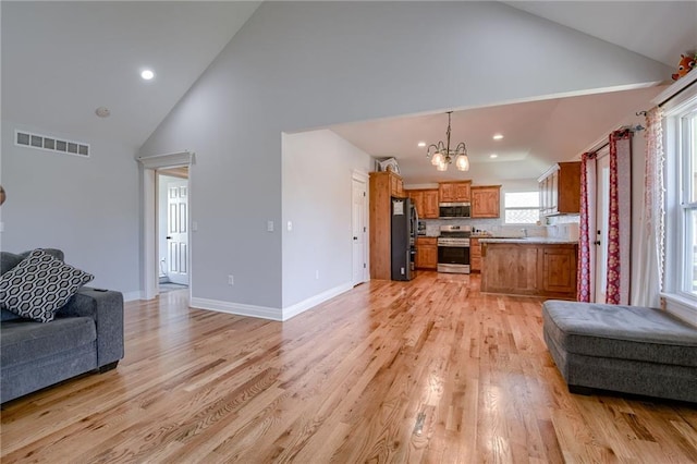21200 W 47th Ter, Shawnee, KS 66218 - living room with high vaulted ceiling, a chandelier, light wood-type flooring, recessed lighting, and baseboards