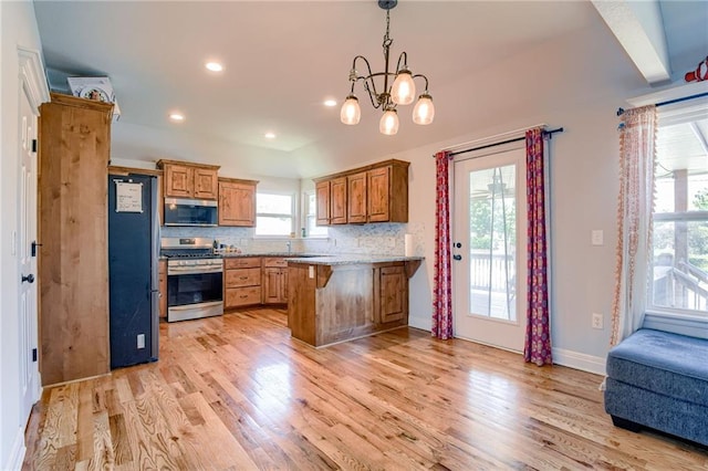 21200 W 47th Ter, Shawnee, KS 66218 - kitchen with appliances with stainless steel finishes, a peninsula, a kitchen bar, brown cabinetry, and recessed lighting