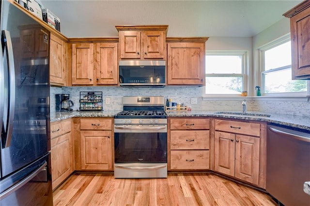21200 W 47th Ter, Shawnee, KS 66218 - kitchen with appliances with stainless steel finishes, a sink, light wood finished floors, light stone countertops, and decorative backsplash
