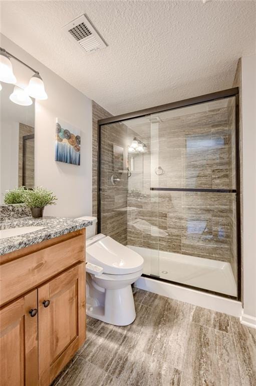 21200 W 47th Ter, Shawnee, KS 66218 - full bathroom with vanity, a stall shower, a textured ceiling, and toilet