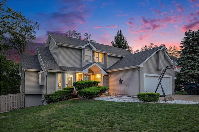 traditional home featuring an attached garage, concrete driveway, and a shingled roof
