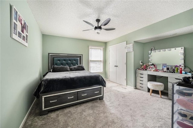 bedroom featuring carpet, a textured ceiling, baseboards, and ceiling fan
