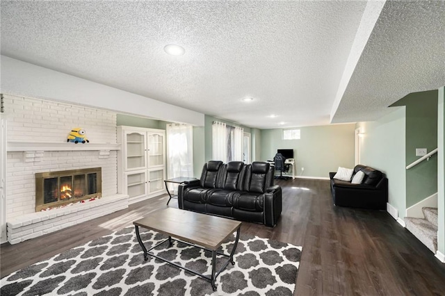 living room featuring a textured ceiling, a fireplace, wood finished floors, stairway, and recessed lighting