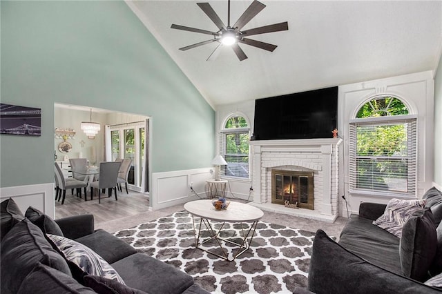 18213 Cliff Dr, Independence, MO 64055 - living area with a ceiling fan, high vaulted ceiling, wainscoting, a fireplace, and a decorative wall