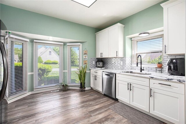18213 Cliff Dr, Independence, MO 64055 - kitchen with stainless steel dishwasher, a sink, healthy amount of natural light, and light stone countertops