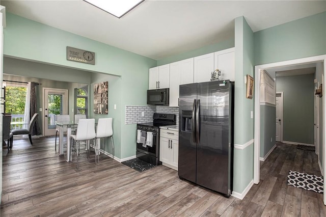 18213 Cliff Dr, Independence, MO 64055 - kitchen with fridge with ice dispenser, stainless steel range with electric cooktop, black microwave, and white cabinetry