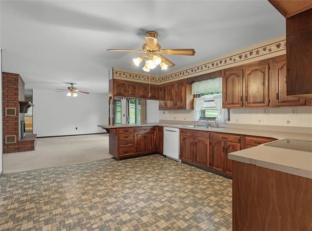 kitchen featuring dishwasher, ceiling fan, a peninsula, a sink, and light countertops