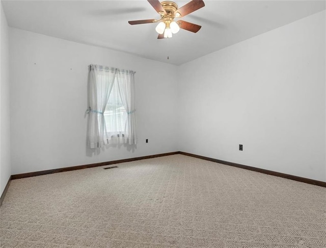 spare room with carpet flooring, a ceiling fan, and baseboards