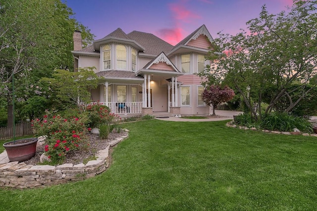 2820 S Victoria Ln, Blue Springs, MO 64015 - victorian house with a chimney, covered porch, a front yard, and a shingled roof