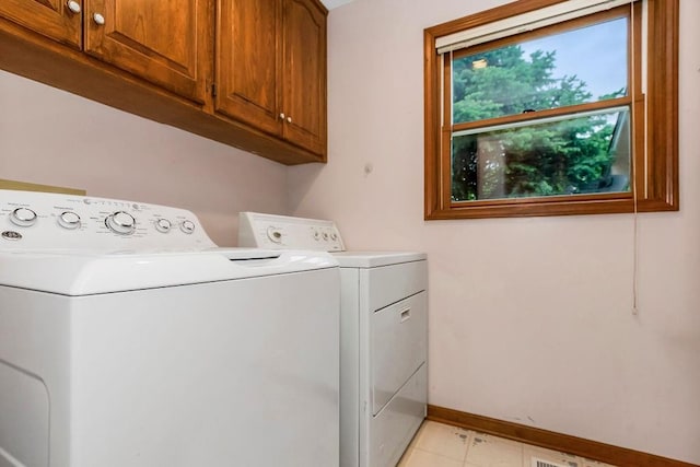 2820 S Victoria Ln, Blue Springs, MO 64015 - clothes washing area with washer and clothes dryer, cabinet space, baseboards, and light tile patterned flooring