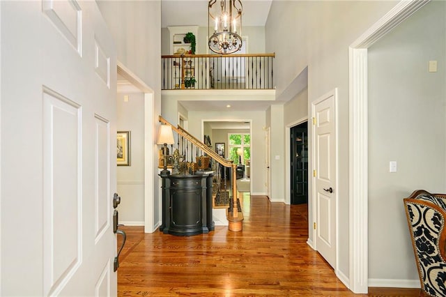 1605 Ridge Rd, Leavenworth, KS 66048 - foyer entrance featuring wood finished floors, stairs, a chandelier, a high ceiling, and baseboards