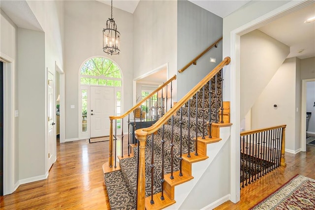1605 Ridge Rd, Leavenworth, KS 66048 - stairway with wood finished floors, baseboards, a chandelier, and a high ceiling