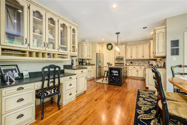1605 Ridge Rd, Leavenworth, KS 66048 - kitchen featuring cream cabinets, stainless steel appliances, dark countertops, glass insert cabinets, and light wood-type flooring