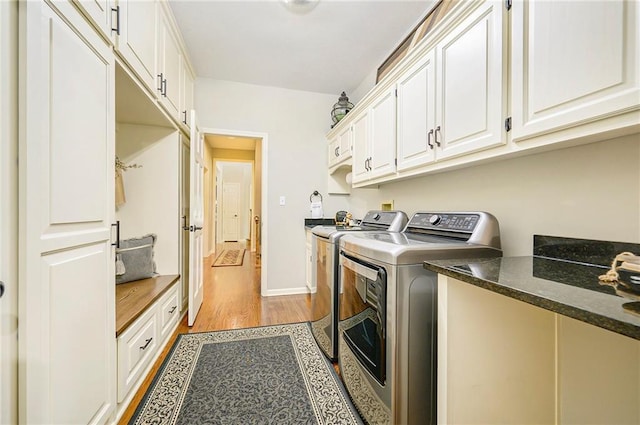 1605 Ridge Rd, Leavenworth, KS 66048 - clothes washing area featuring independent washer and dryer, cabinet space, light wood-style flooring, and baseboards