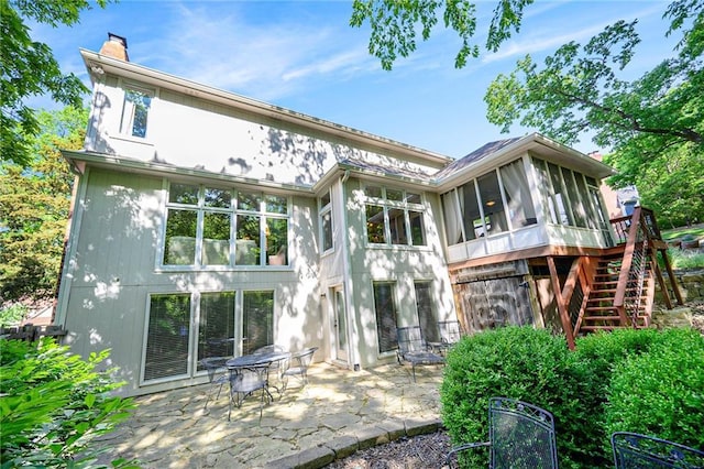 1605 Ridge Rd, Leavenworth, KS 66048 - rear view of property featuring a sunroom, a patio, a chimney, and stairway