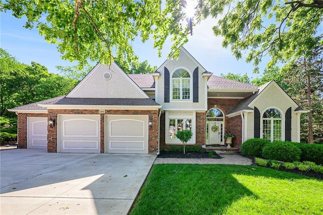 1605 Ridge Rd, Leavenworth, KS 66048 - view of front facade with an attached garage, concrete driveway, a front yard, and brick siding