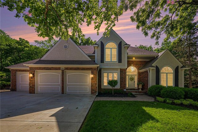 1605 Ridge Rd, Leavenworth, KS 66048 - view of front of house with an attached garage, concrete driveway, a yard, and brick siding