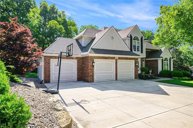 1605 Ridge Rd, Leavenworth, KS 66048 - view of front of property featuring an attached garage, concrete driveway, brick siding, a shingled roof, and stucco siding