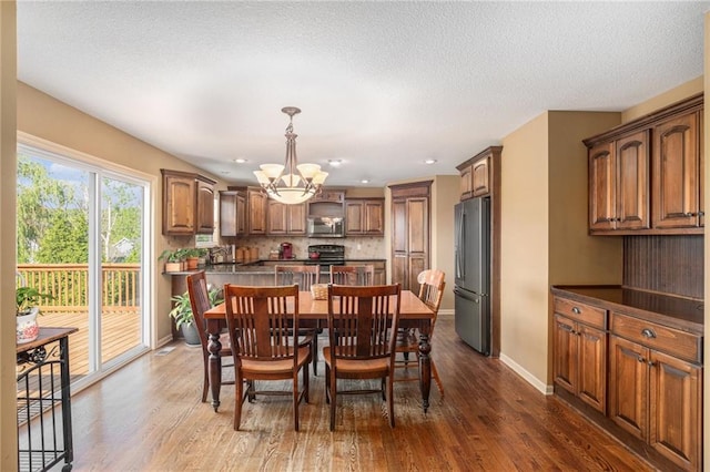 dining area featuring a chandelier, wood finished floors, baseboards, and recessed lighting