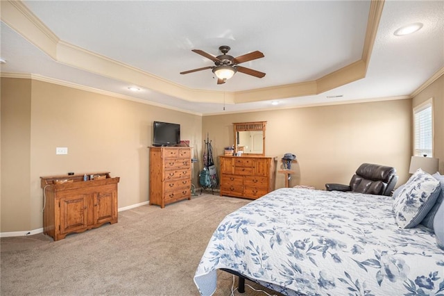 bedroom featuring a tray ceiling, ornamental molding, light colored carpet, baseboards, and a ceiling fan