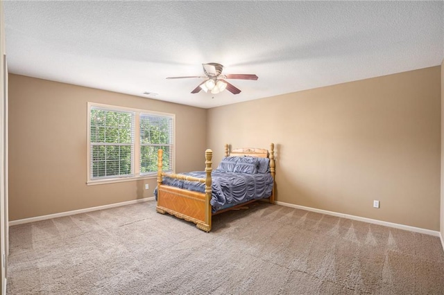 bedroom featuring carpet, baseboards, a ceiling fan, and a textured ceiling