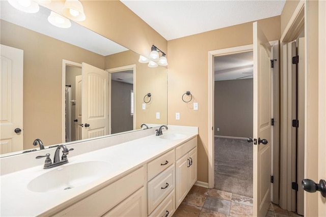 bathroom with double vanity and baseboards