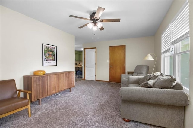 living area featuring carpet, a ceiling fan, and baseboards