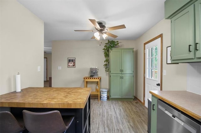 kitchen with dishwasher, green cabinetry, ceiling fan, light wood-type flooring, and a peninsula