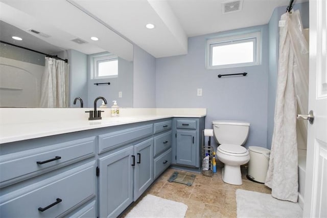 bathroom featuring recessed lighting, toilet, vanity, stone finish floors, and a shower with curtain