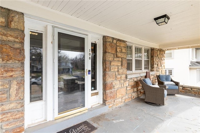 108 W 61st Ter, Kansas City, MO 64113 - doorway to property featuring stone siding and a porch