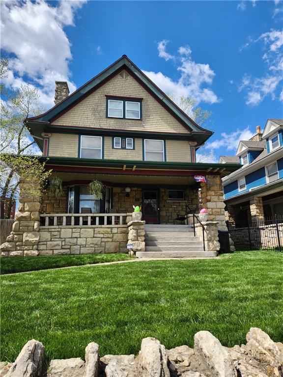 3744 Walnut St, Kansas City, MO 64111 - rear view of property with a porch, a chimney, and stone siding