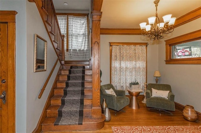 3744 Walnut St, Kansas City, MO 64111 - stairway featuring a chandelier, wood finished floors, baseboards, and crown molding