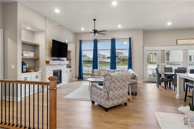 9424 N Belleview Ave, Kansas City, MO 64155 - living area with a ceiling fan, light wood-style flooring, a stone fireplace, recessed lighting, and built in features