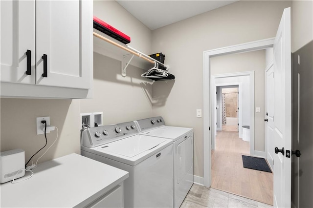 9424 N Belleview Ave, Kansas City, MO 64155 - clothes washing area with cabinet space, washing machine and clothes dryer, baseboards, and light wood finished floors