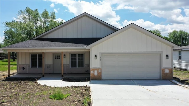 view of front of house with roof with shingles, a garage, a porch, concrete driveway, and board and batten siding