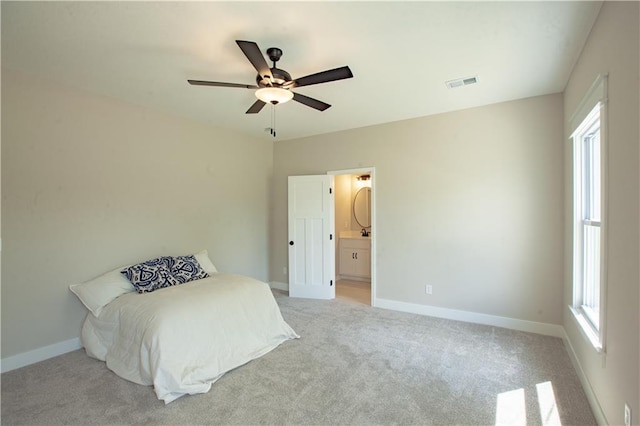 bedroom featuring multiple windows, light colored carpet, and baseboards
