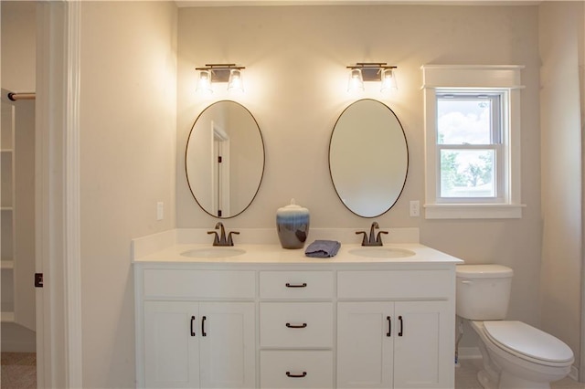 bathroom featuring toilet and double vanity
