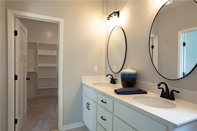 bathroom featuring double vanity and a walk in closet