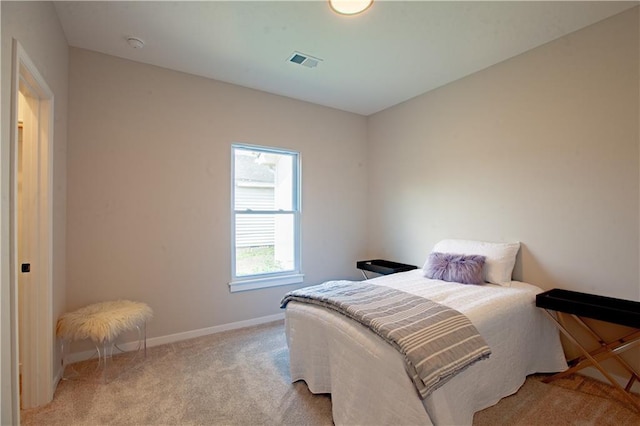 bedroom featuring light carpet and baseboards