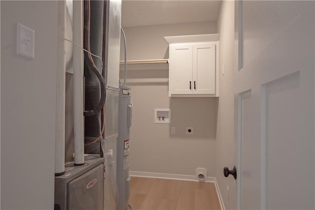laundry room with cabinet space, electric dryer hookup, light wood finished floors, hookup for a washing machine, and baseboards