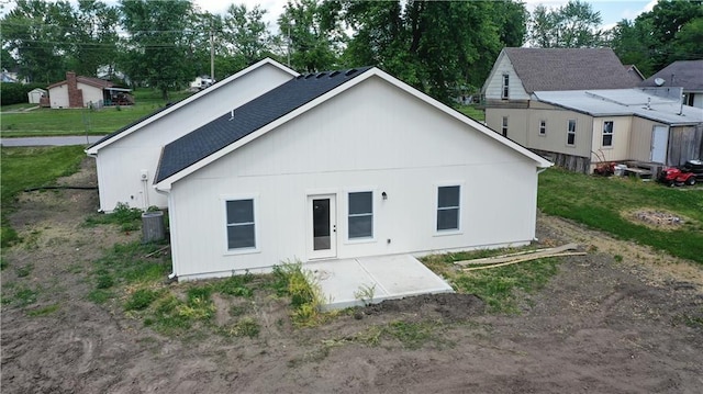 rear view of property featuring a patio, central air condition unit, and a shingled roof