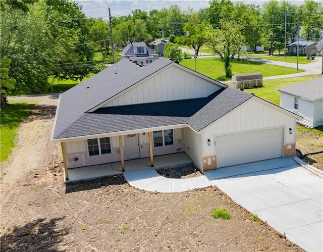 606 E 3rd St, Cameron, MO 64429 - modern inspired farmhouse with roof with shingles, concrete driveway, an attached garage, a porch, and board and batten siding