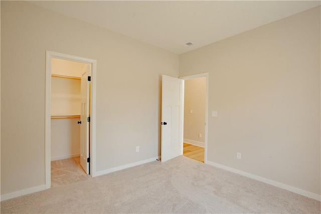606 E 3rd St, Cameron, MO 64429 - unfurnished bedroom featuring carpet, a spacious closet, and baseboards