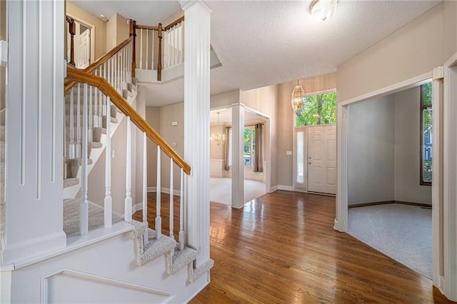 6209 NW 78th St, Kansas City, MO 64151 - entryway featuring a chandelier, wood finished floors, stairs, a textured ceiling, and baseboards