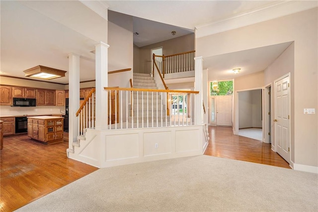 6209 NW 78th St, Kansas City, MO 64151 - unfurnished living room featuring light carpet, stairs, light wood finished floors, ornamental molding, and baseboards