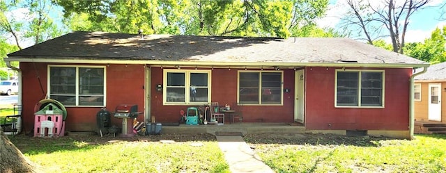 view of front of property featuring roof with shingles and a front lawn