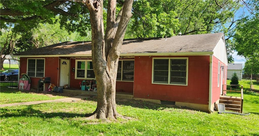 view of front of home featuring a shingled roof and a front yard