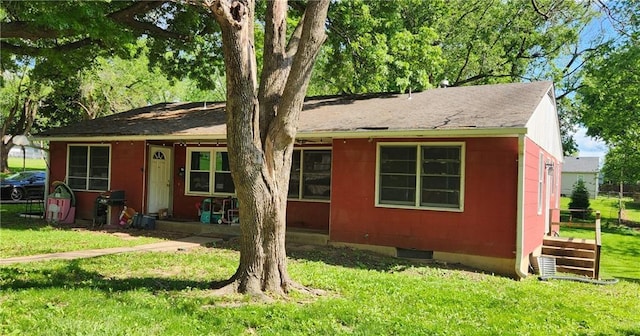 view of front of home featuring a shingled roof and a front yard