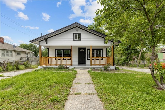 3107 N 34th St, Kansas City, KS 66104 - bungalow-style home with covered porch and a front lawn